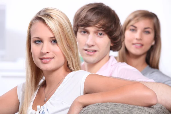 Three teenage friends sitting and relaxing on sofa — Stock Photo, Image