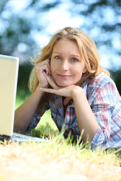 Nő, bámult az űrbe, miközben dolgozik kívül a laptop számítógép — Stock Fotó