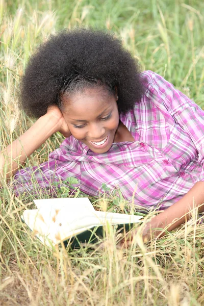 Γυναίκα διαβάζοντας ένα διασκεδαστικό βιβλίο σε ένα πεδίο — Φωτογραφία Αρχείου