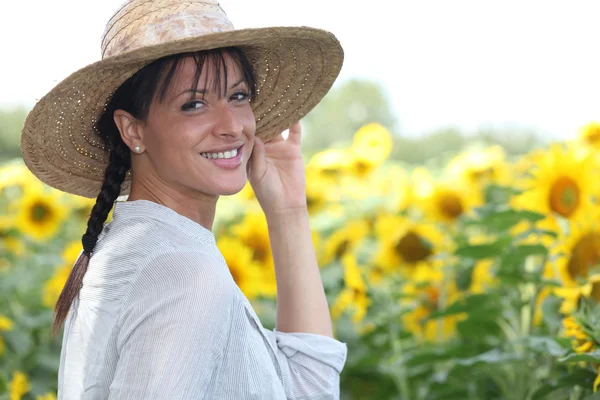 Jonge vrouw in een zonnebloem veld — Stockfoto