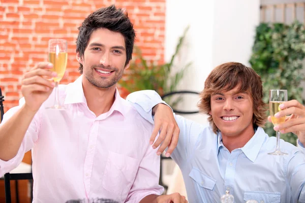 Hombres bebiendo champán en un bar — Foto de Stock