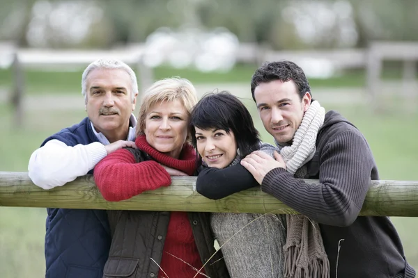 Семья, опирающаяся на забор — стоковое фото