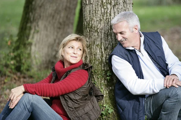 Пара средних лет сидела у дерева — стоковое фото