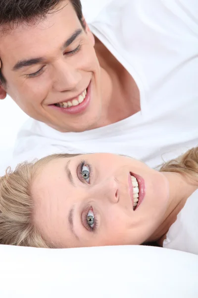Sorridente giovane coppia sdraiata — Foto Stock
