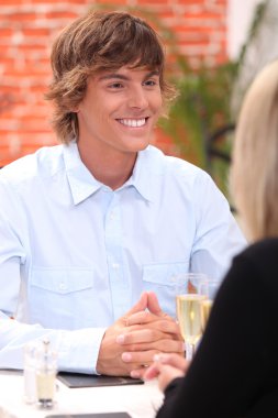 Smiling young man in a restaurant clipart