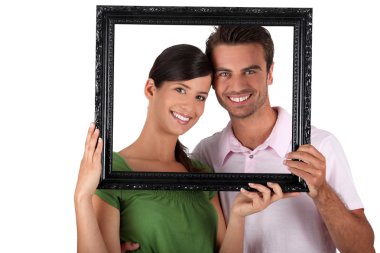 Couple stood with empty picture frame clipart