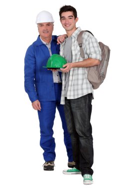 Young apprentice posing with his new boss on his first day of work clipart