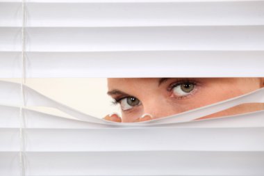 Woman peering through blinds clipart