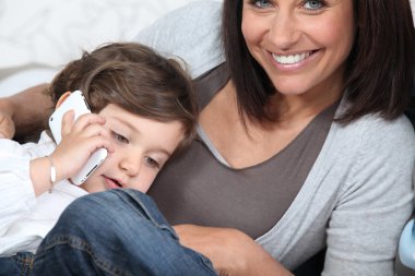 Child using his mother's cellphone clipart