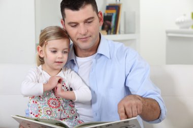 Father reading a story to his daughter clipart