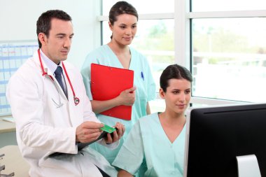 The hospital workers gathered around computer clipart