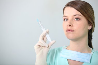 Brunette nurse holding syringe clipart