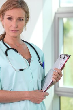 Female doctor with stethoscope and clipboard clipart