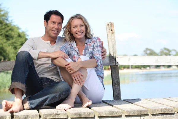 Paar sitzt an einem See — Stockfoto