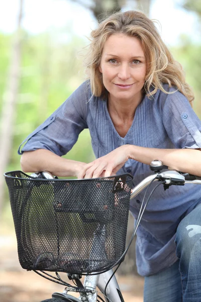 Kvinna ridning cykel i skogen — Stockfoto