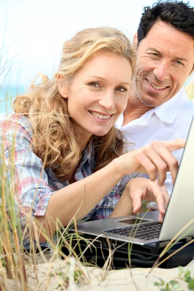 Casal olhando para laptop ao ar livre . — Fotografia de Stock
