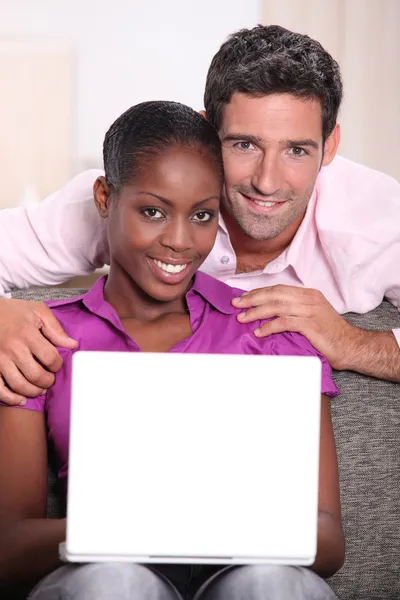Interracial paar mit einem laptop. — Stockfoto