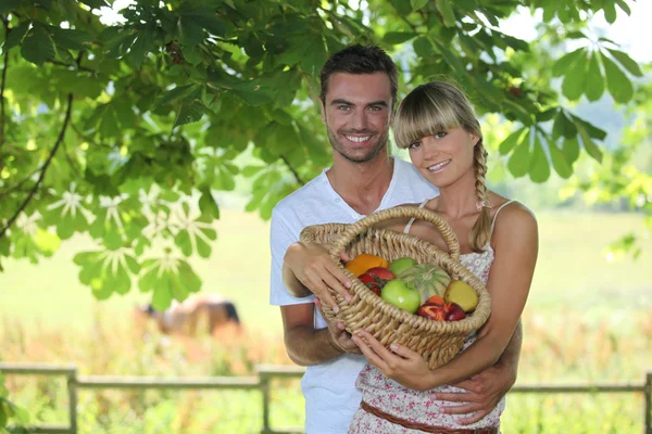 Par med en korg med frukter — Stockfoto