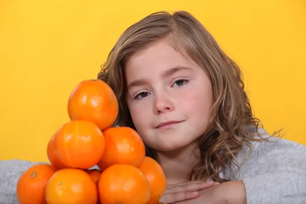 Petit se tenait avec pile d'oranges — Photo