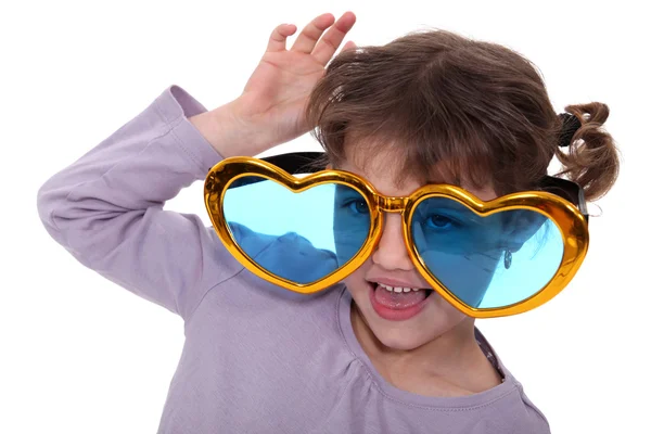Young girl wearing oversized heart-shaped glasses — Stock Photo, Image