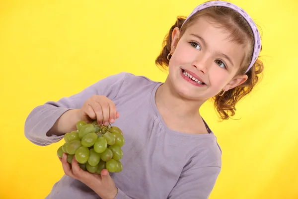 Girl with a bunch of grapes — Stock Photo, Image