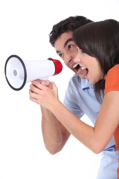 Jovem casal gritando em um alto-falante — Fotografia de Stock