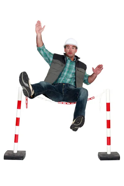 Trabalhador que cai sobre uma barreira de segurança — Fotografia de Stock