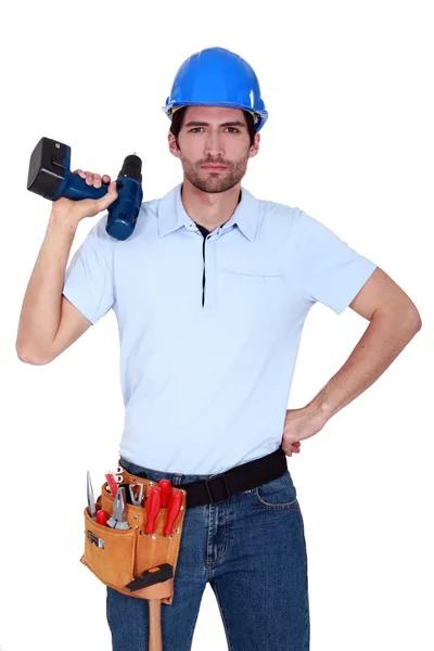 Irritated tradesman holding a battery-powered screwdriver — Stock Photo, Image