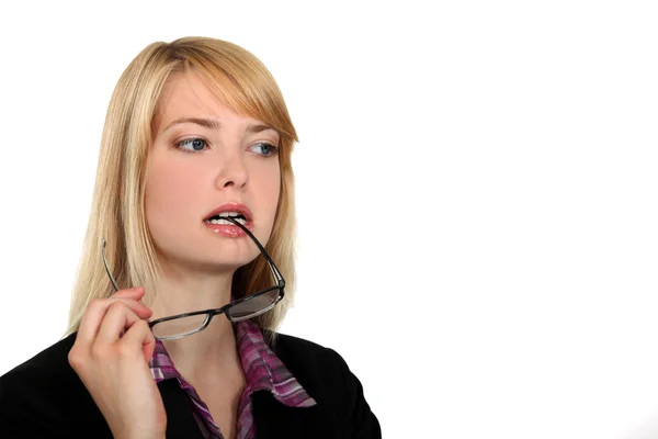 Attraente donna masticare i suoi occhiali — Foto Stock