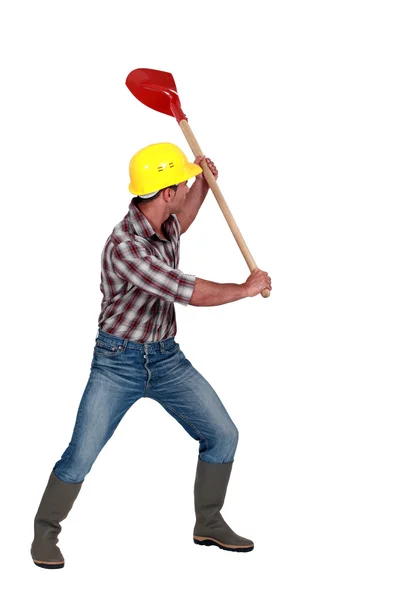 Workman розмахуючи лопатою на білому тлі — стокове фото