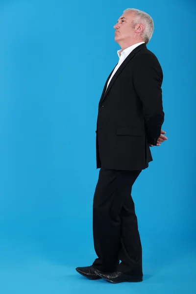 Zralý muž, stojící v profilu modré pozadí — Stock fotografie
