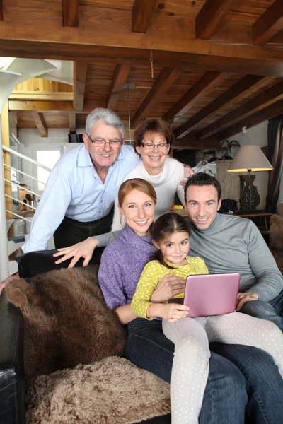 Familia reunida alrededor del ordenador portátil —  Fotos de Stock