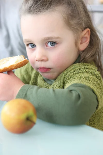 Portrait of a little girl eating a sandwich — Stock Photo, Image