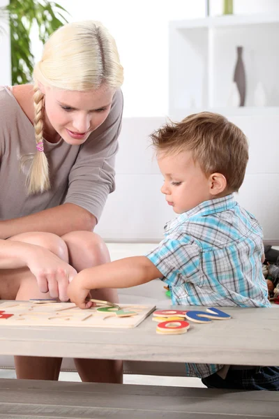 Mother and son doing a jigsaw puzzle — Stock Photo, Image