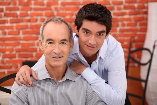 Een tiener en zijn grootvader die zich voordeed in een restaurant — Stockfoto