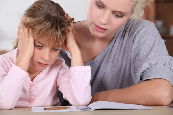 Madre aiutare sua figlia con i suoi compiti . — Foto Stock