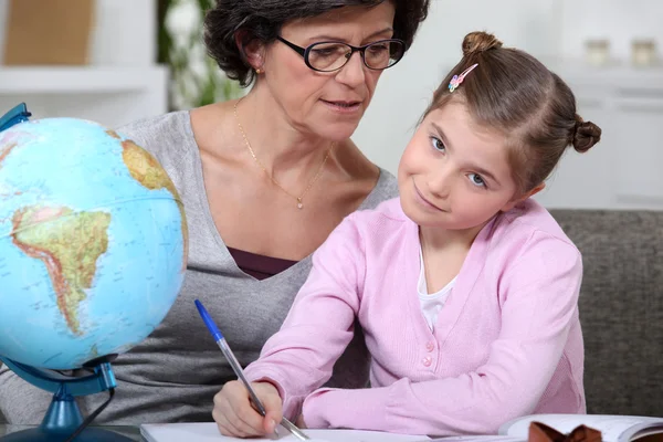 Mãe ajudando sua filha com seu dever de casa . — Fotografia de Stock