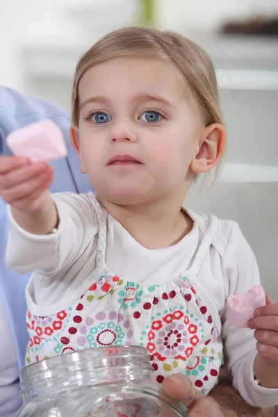 Kleines Mädchen bietet Marshmallows an — Stockfoto