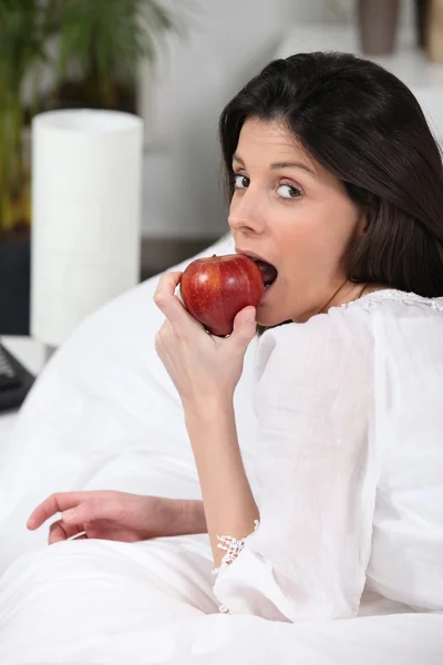 Černovlasá bourgeoise křupavý červené jablko — Stock fotografie