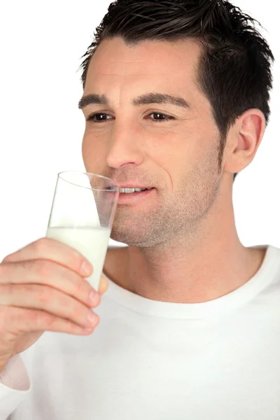 Junger Mann trinkt ein Glas Milch — Stockfoto