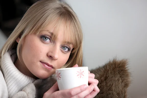 Kvinnan satt på soffan dricka kaffe — Stockfoto
