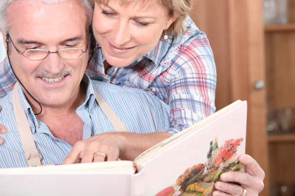 Ouder paar met een kookboek — Stockfoto