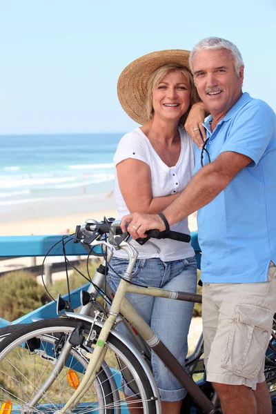 Ώριμο ζευγάρι με ποδήλατα από τη μια παραλία — Φωτογραφία Αρχείου