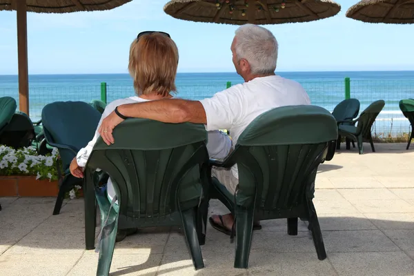 Középső idős házaspár, pihenés a tengerparton. — Stock Fotó