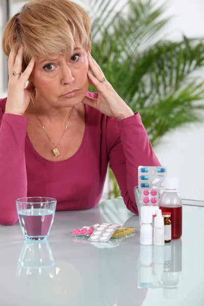 Пожилая женщина беспокоится о своих таблетках — стоковое фото