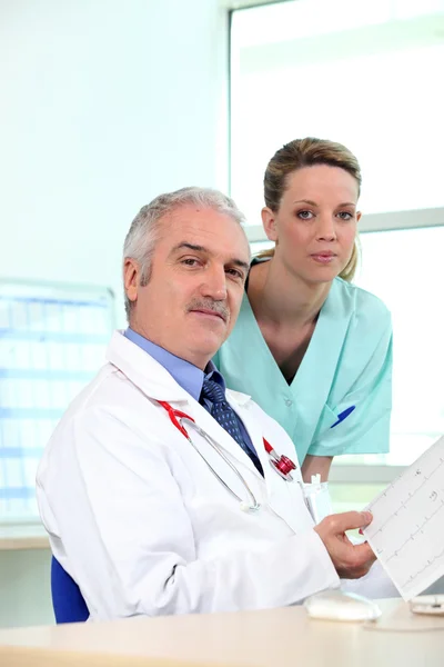 Um médico e uma enfermeira olhando para alguns resultados — Fotografia de Stock