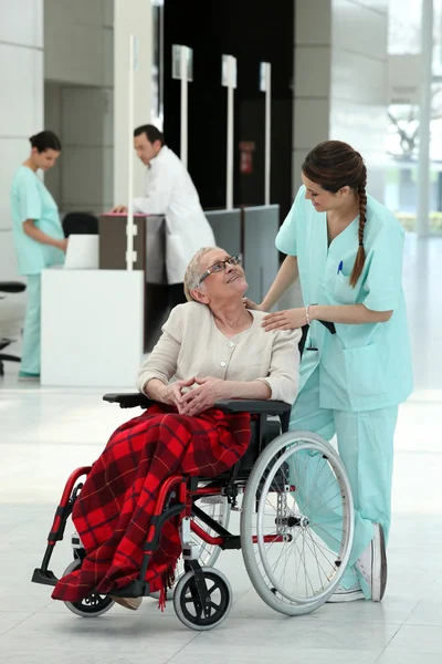 Pielęgniarki z starsza pani na wózku inwalidzkim — Zdjęcie stockowe