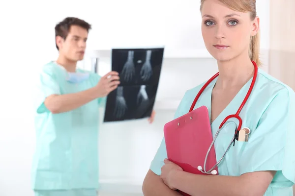 Médicos mirando las radiografías de una mano — Foto de Stock