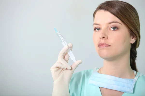 Brunette nurse holding syringe — Stock Photo, Image