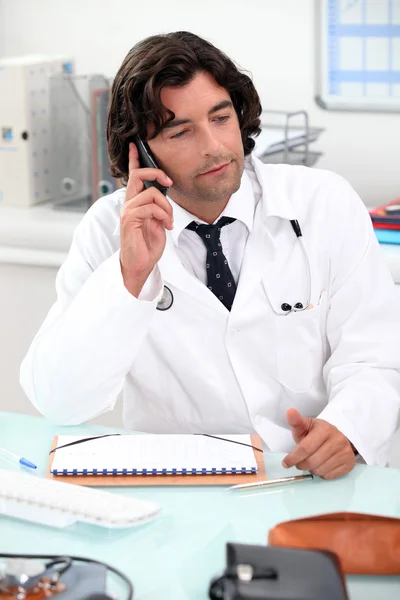 Medico che utilizza un telefono alla scrivania — Foto Stock